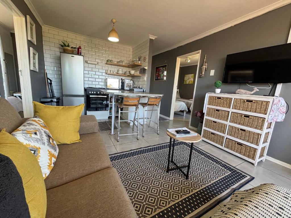 ヘルマナスにある#FiftySevenのソファとキッチンのあるリビングルーム