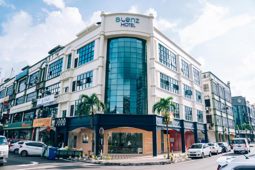 a building on a city street with cars parked at Blenz Hotel in Serdang