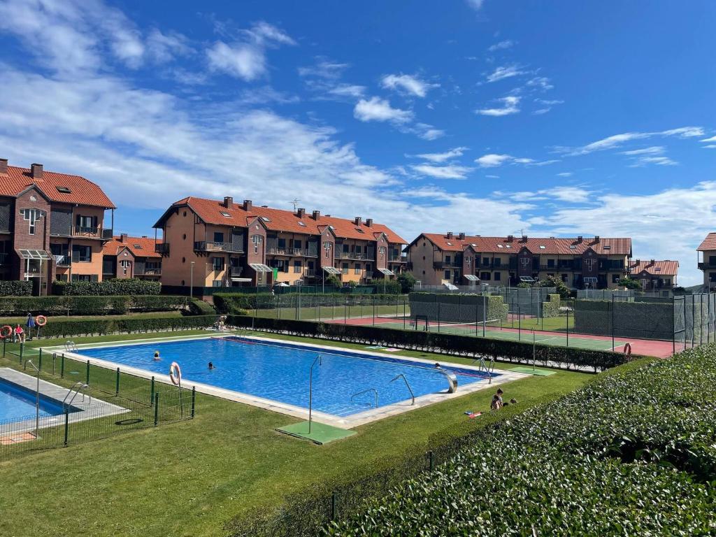 a large swimming pool in front of some houses at Apartamento Aventuras in Comillas