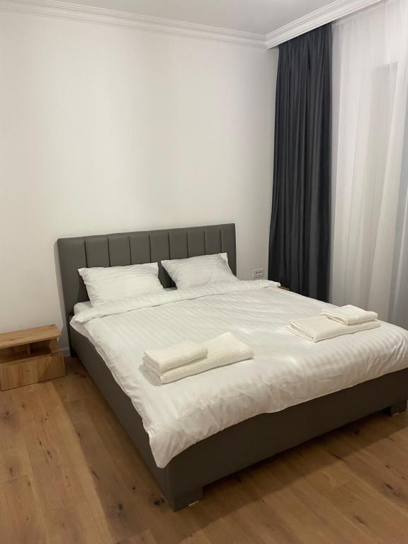 a bed with two white towels on top of it at Apartament in Ipotești in Ipoteşti