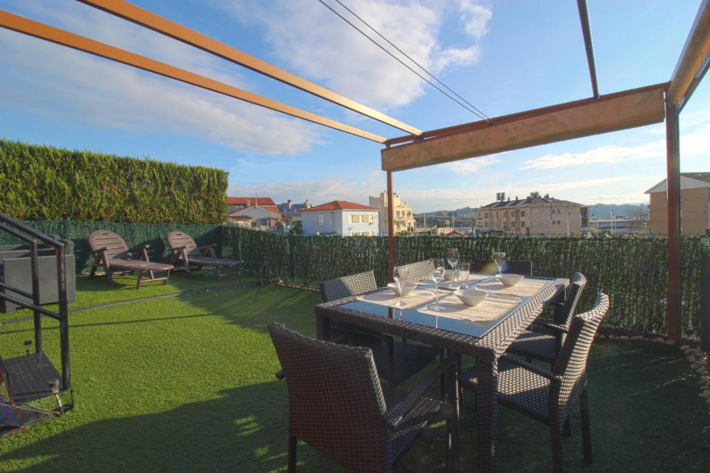 a table and chairs on a patio with a view at La Casa del Muelle in Suances
