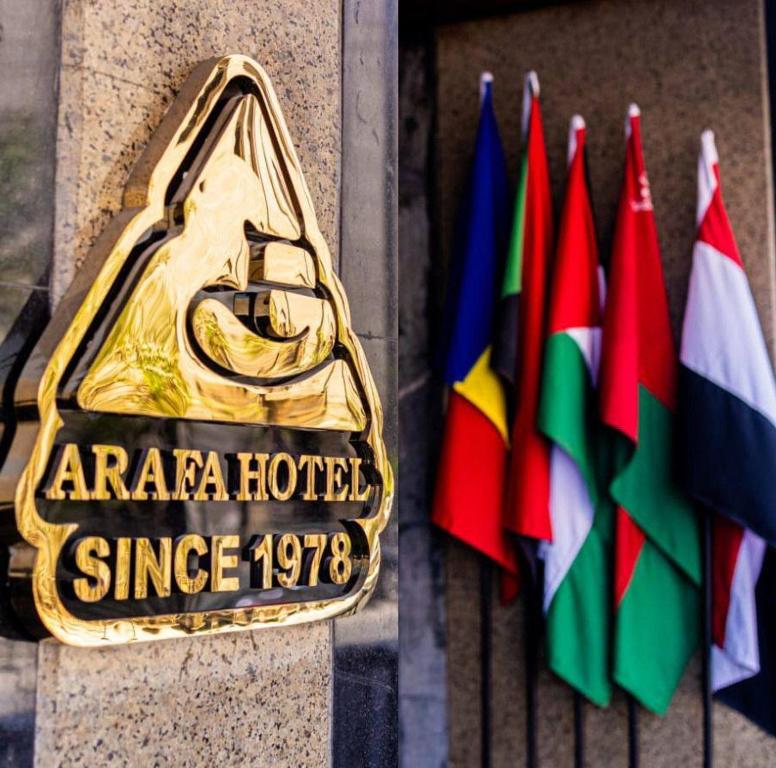 a gold sign on a building next to flags at فندق عرفه الجديد in Tanta