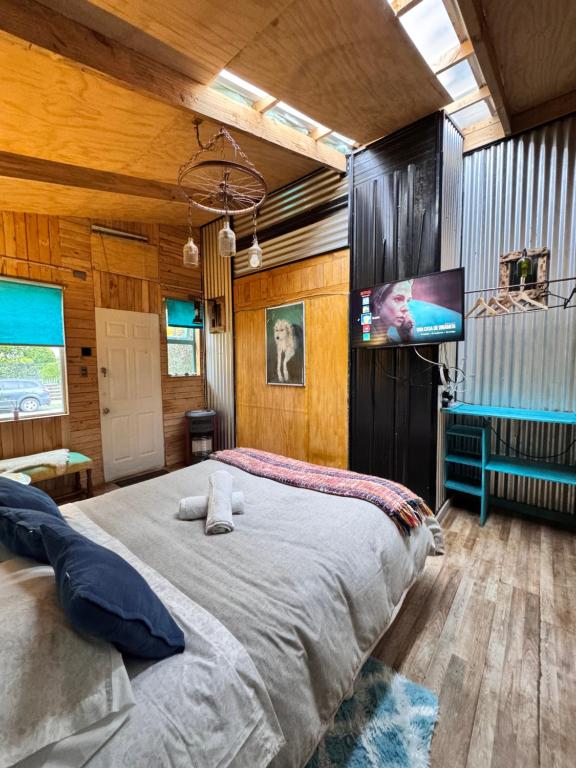 Un dormitorio con una cama grande y un televisor de pantalla plana. en Apartamento Hortensias del Lago, en Puerto Varas