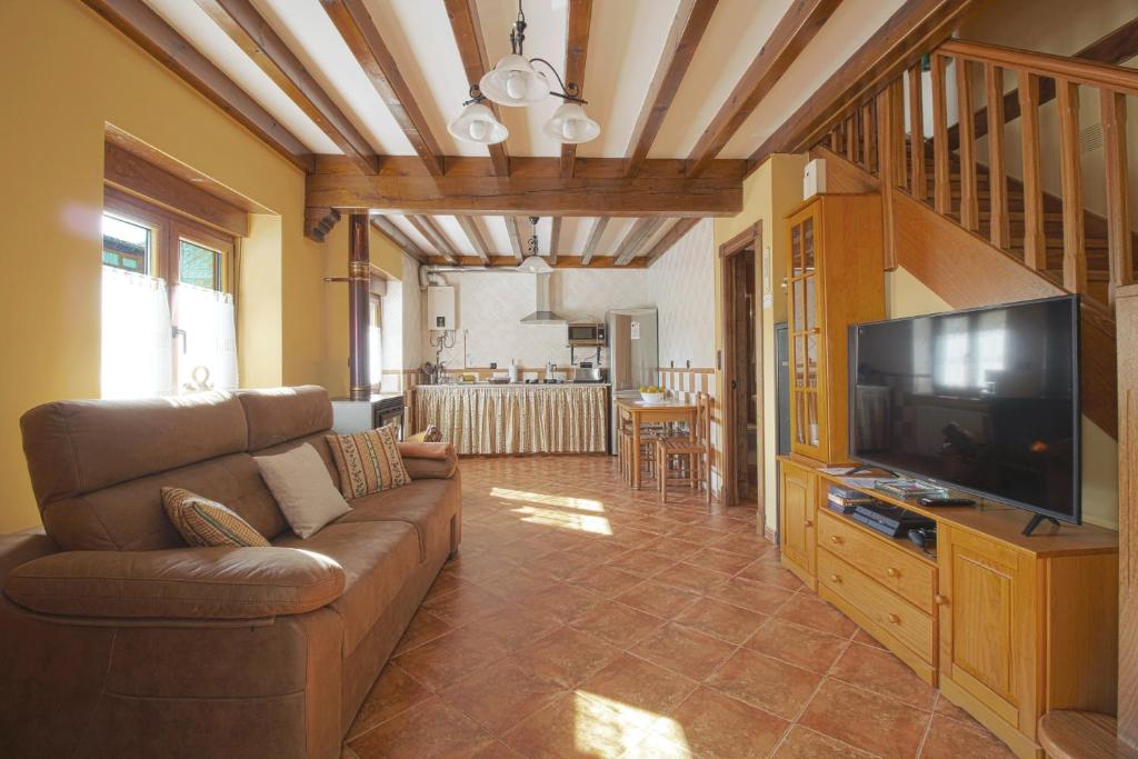 Una sala de estar con un sofá y un televisor de pantalla plana. en Casa Yito, en Muñorrodero