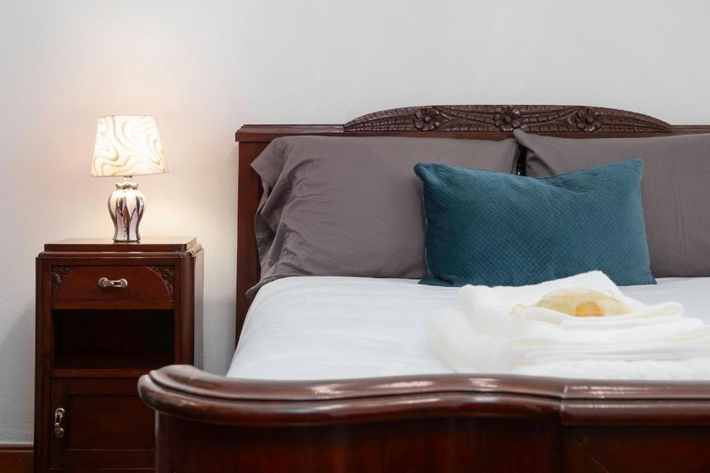 een bed met een blauw kussen en een lamp op een nachtkastje bij Casa da Avó in Vila Franca do Campo