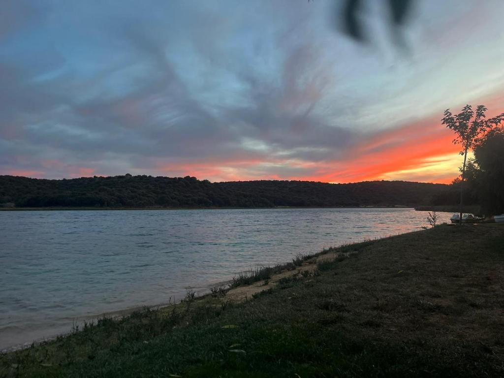 a sunset on the shore of a body of water at El descanso soberano in Ossa de Montiel