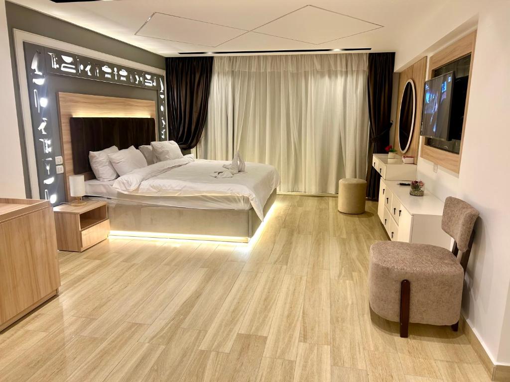 a large bedroom with a bed and a television in it at The diamond pyramids view inn in Cairo