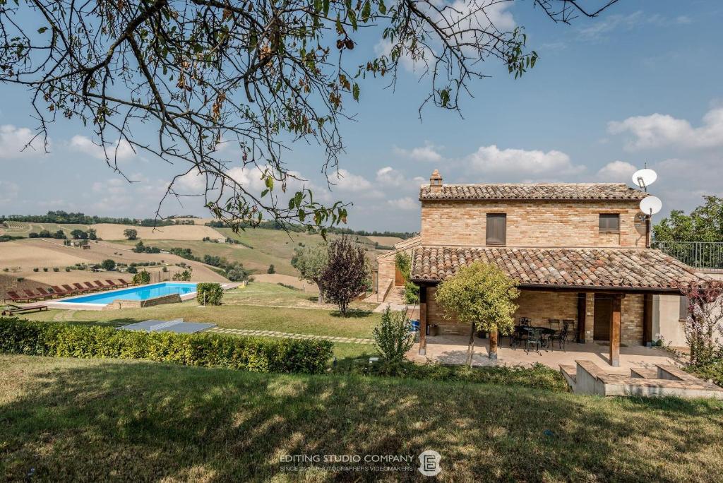 vista esterna sulla casa e sulla piscina di Italian Experience-Villa la Dolcevita a Montegiorgio