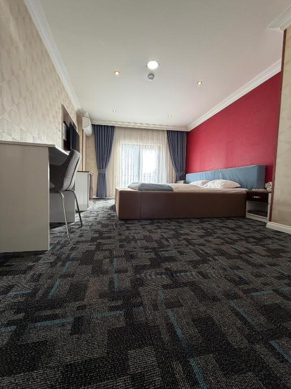 a bedroom with a bed and a red wall at Hotel Dosco in Van