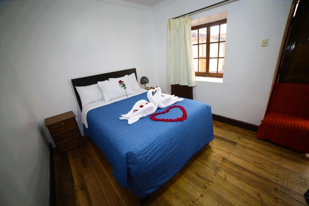 Un dormitorio con una cama con dos toallas encima. en Hostal el Conquistador, en Cusco