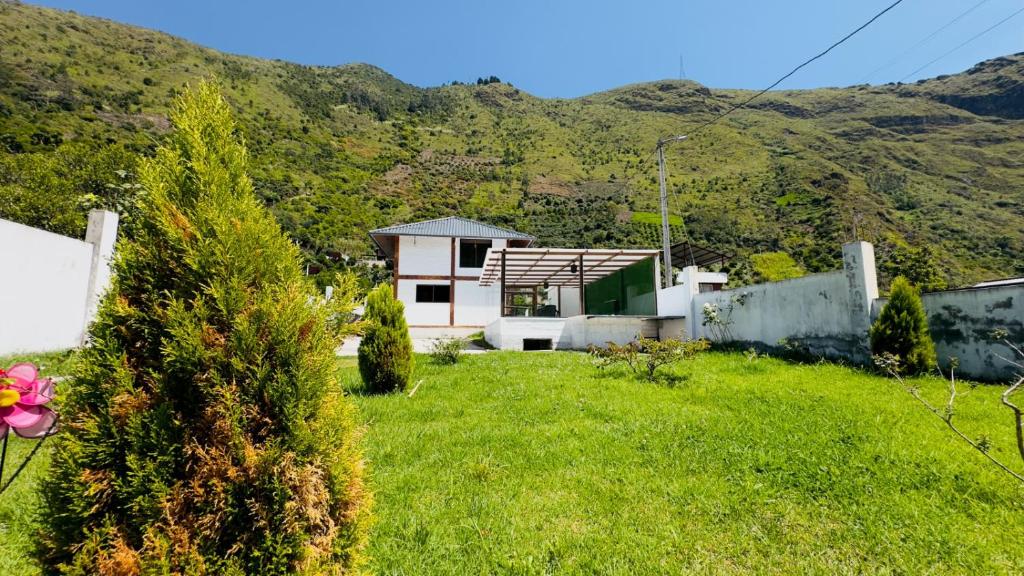 ein Haus mit einem grünen Hof mit Bergen im Hintergrund in der Unterkunft La Villa de Luci in Juivi
