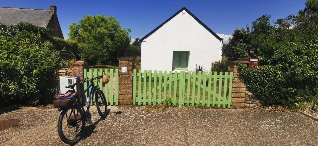 a bike parked in front of a house with a fence at Jolie maison à 700 m de la mer in Piriac-sur-Mer