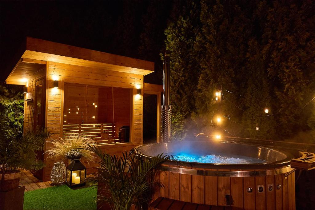 a hot tub in a backyard at night at Villa Beskidzka 100 - SAUNA & BALIA z Jacuzzi Widok na góry i jezioro żywieckie in Zarzecze