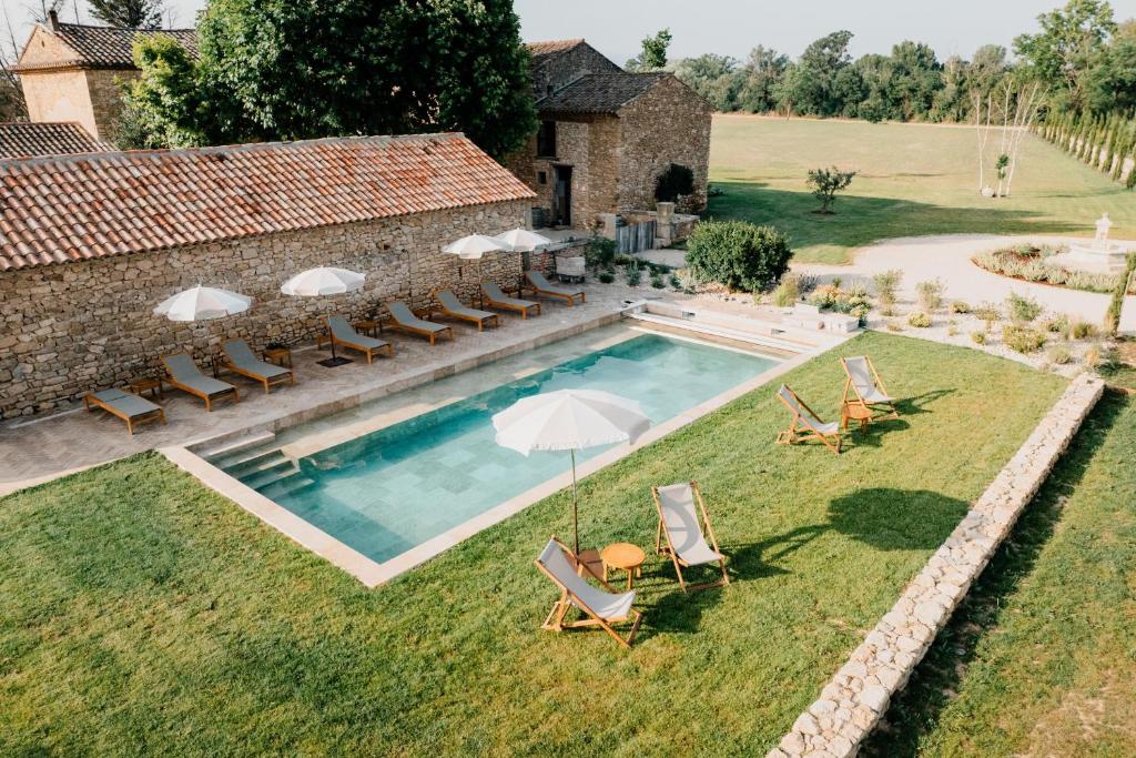 an overhead view of a swimming pool with chairs and umbrellas at Terres Élaïs in Robion en Luberon