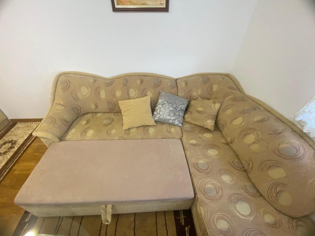 a couch with two pillows on it in a room at Look Apartman in Vrnjačka Banja