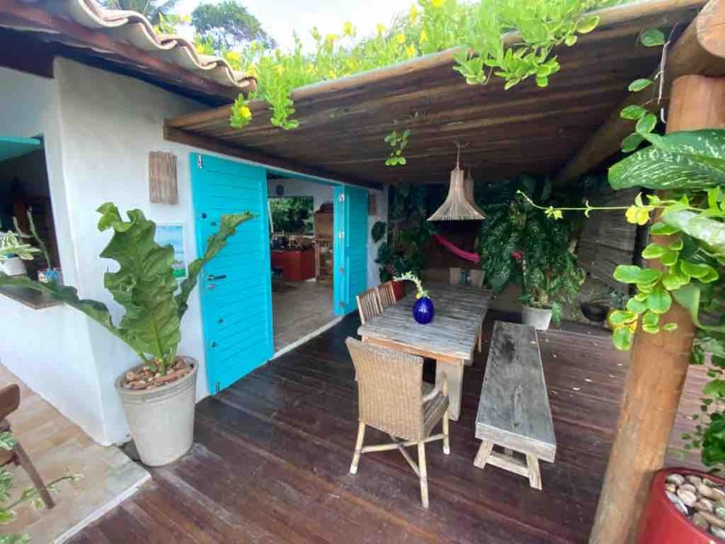 a patio with a wooden table and chairs and a blue door at Casa Paracatoá - Icapuí in Icapuí