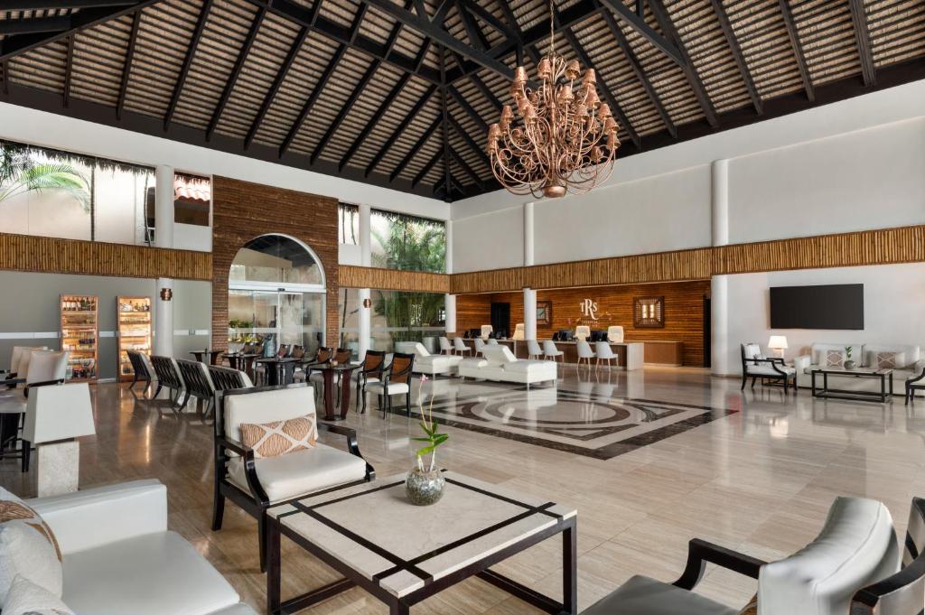 Large indoor lobby with copper chandelier, seating areas, and bar counter with wood accents.