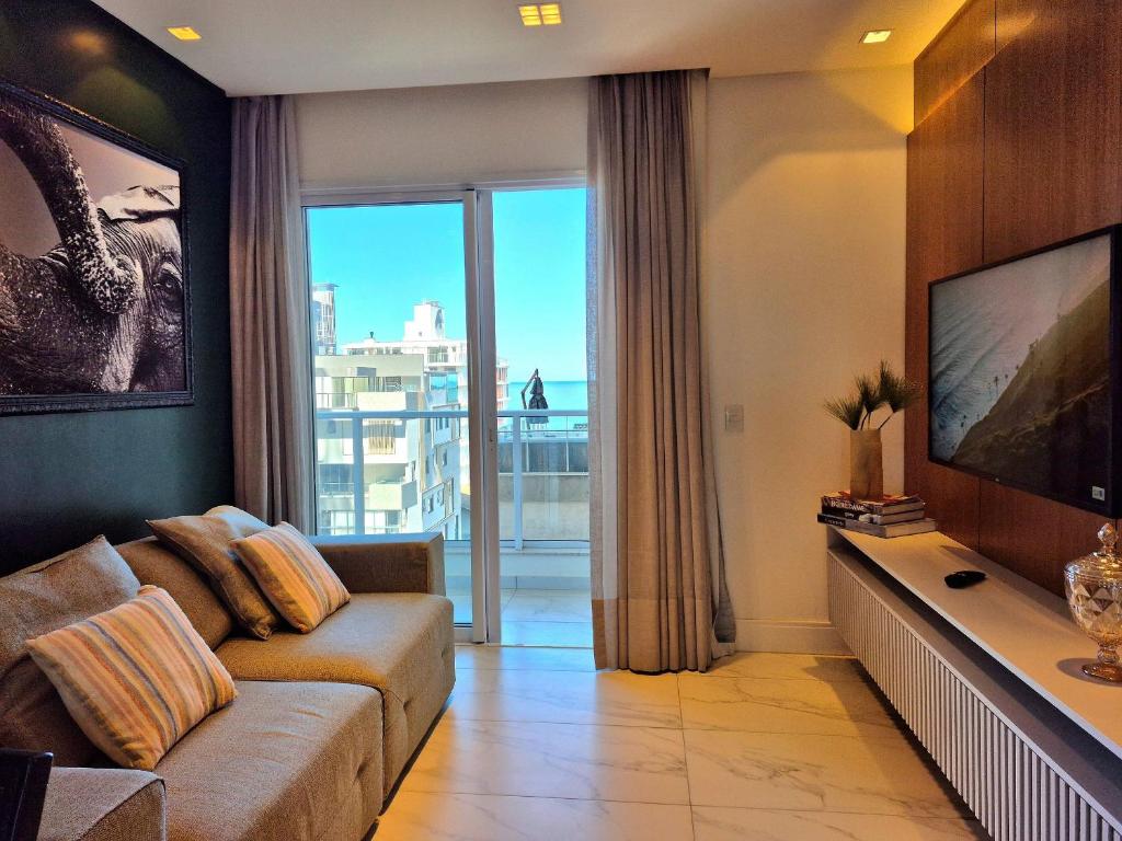 a living room with a couch and a large window at CURTA!|216|Brava Arts|2 Suítes| Sofisticada Vista in Cabeçudas