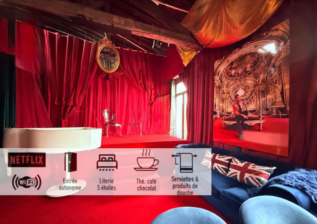 a room with red curtains and a person sitting at a table at 10 Très Grande Chambre insolite double volume XL, proximité gare de tourcoing in Tourcoing