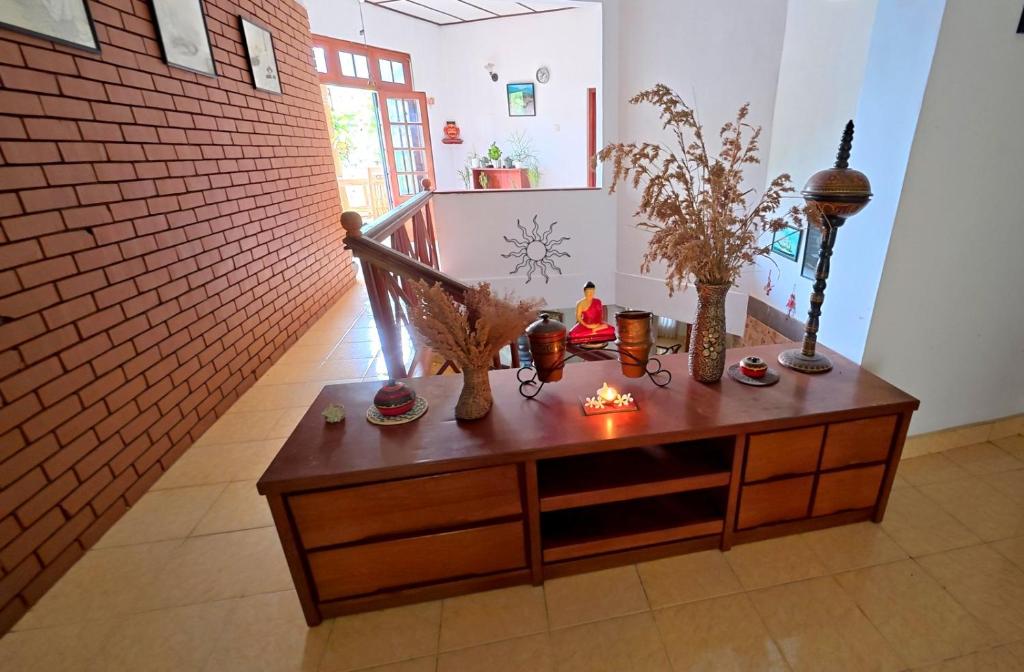a room with a wooden cabinet with vases on it at Ceylon Bliss Retreat- Kandy Wellness Hotel in Kandy