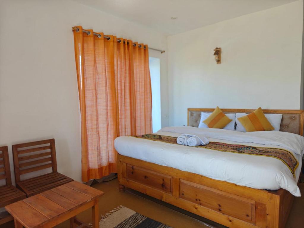 a bedroom with a bed and a chair at Buransh Retreat in Jageshwar