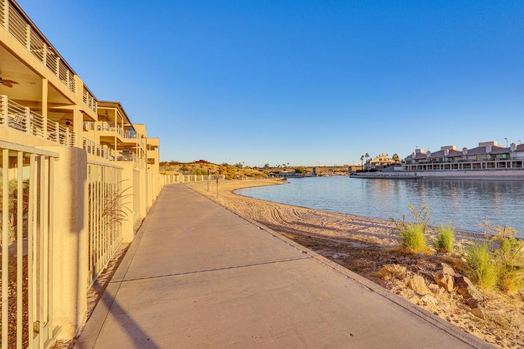 a sidewalk next to a river next to a building at Balcony and Grill Beachfront Lake Havasu City Condo in Lake Havasu City