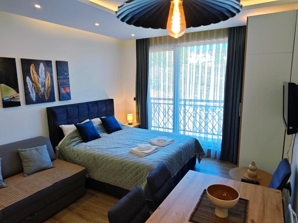 a bedroom with a blue bed and a couch at Harmony, Residence Hill A85 in Kopaonik