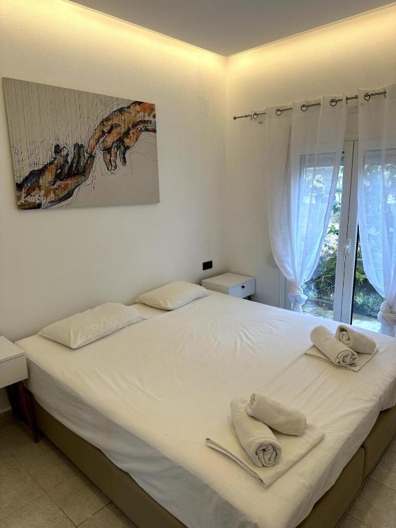a bedroom with a white bed with towels on it at Athos studio in Análipsis