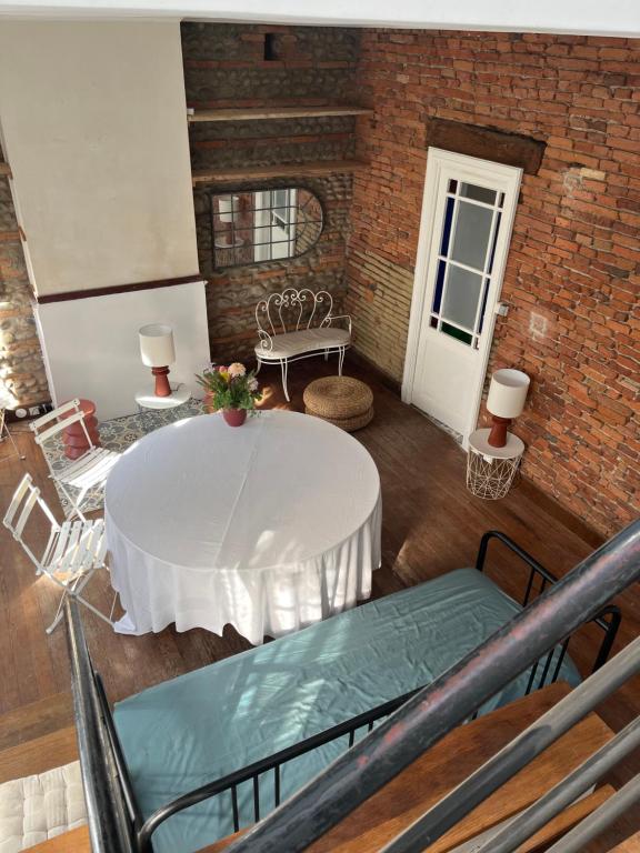 un salon avec une table et des chaises blanches dans l'établissement Maison Bonnefoy, à Toulouse