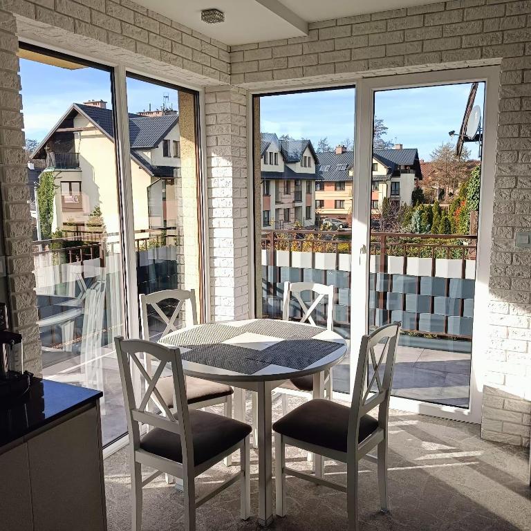 a table and chairs on a patio with a balcony at Apartament Brzeg in Brzeg