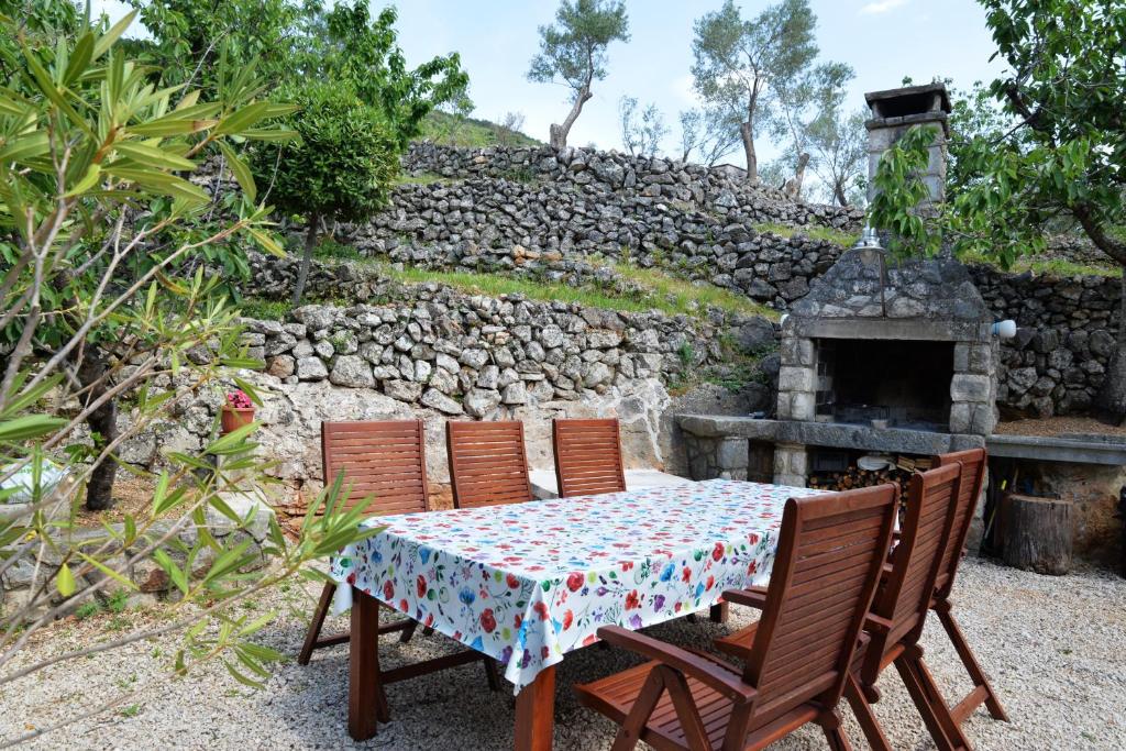 a table with four chairs and a stone fireplace at Apartments with parking space Cres - 7876 in Cres