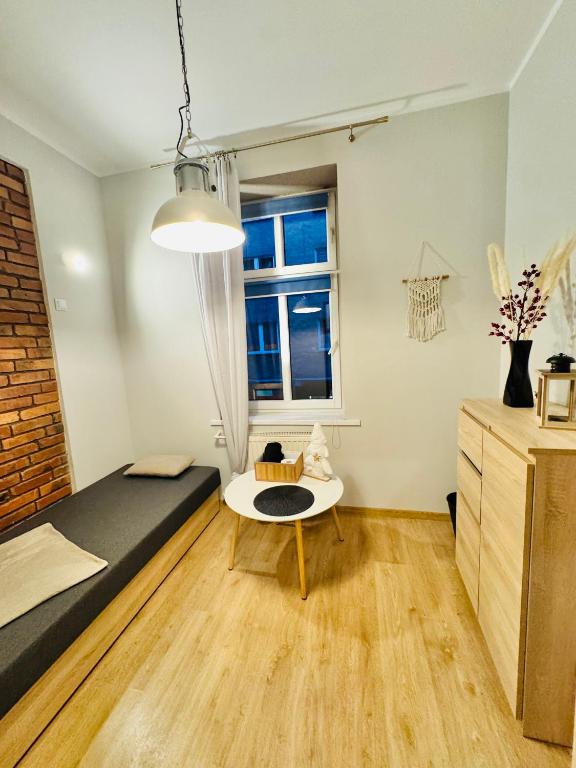a bedroom with a bed and a table and a window at Pokój Przy Parku Róż in Chorzów