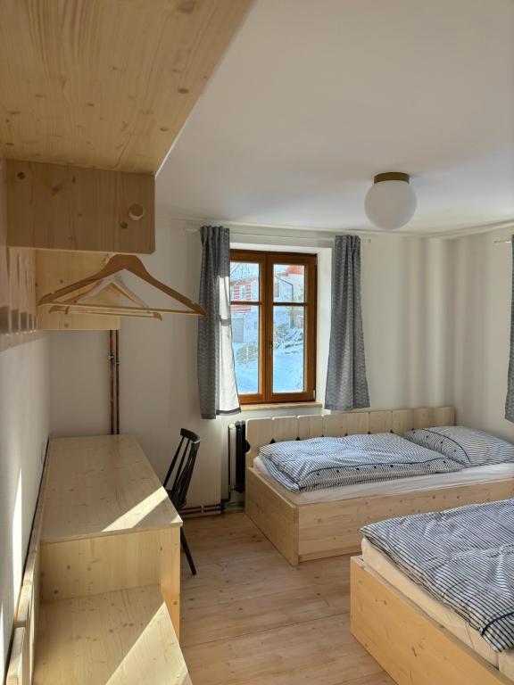 ヤノフ・ナト・ニソウにあるVila Hraničnáのベッド2台と机と窓のある寝室