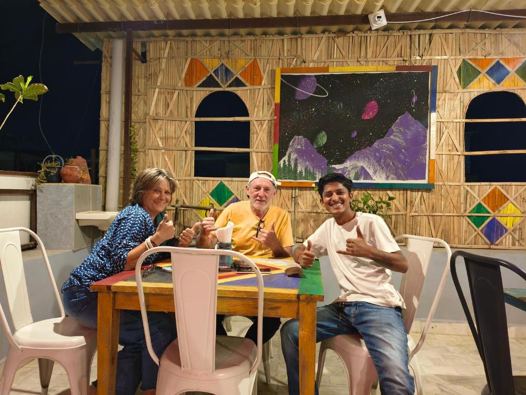 um grupo de pessoas sentadas ao redor de uma mesa em Incredible's Hostel & Safari em Jaisalmer