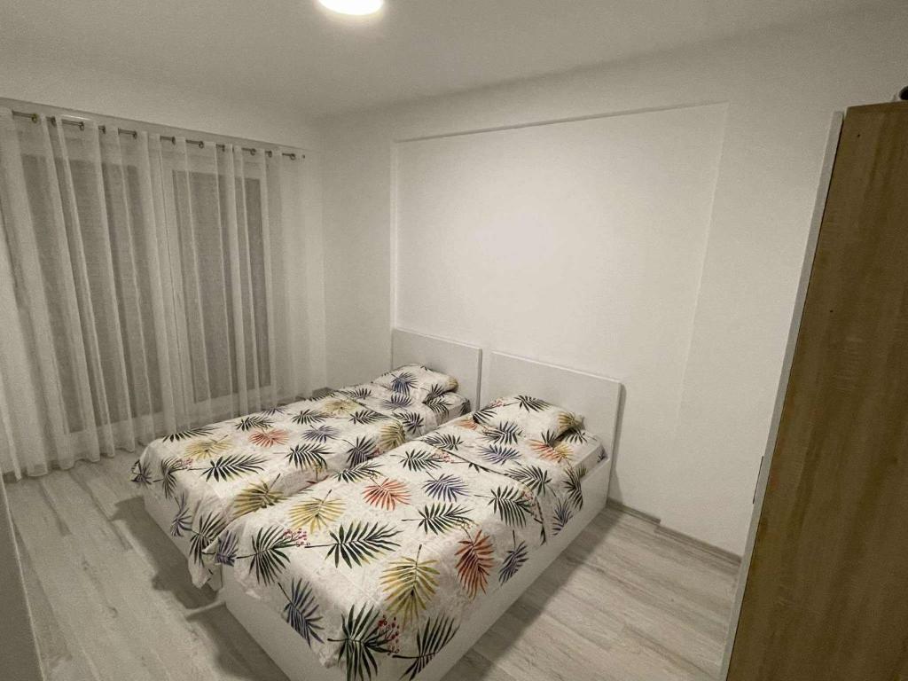 a bedroom with a bed with a floral bedspread at PrishtinaRoyalty in Pristina