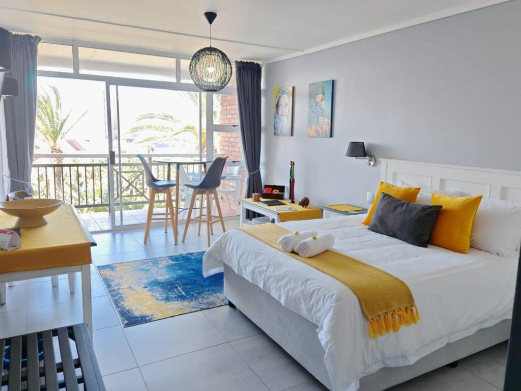 ein Schlafzimmer mit großem Bett und ein Esszimmer in der Unterkunft Brookes Hill Suites Bay Watch in Summerstrand