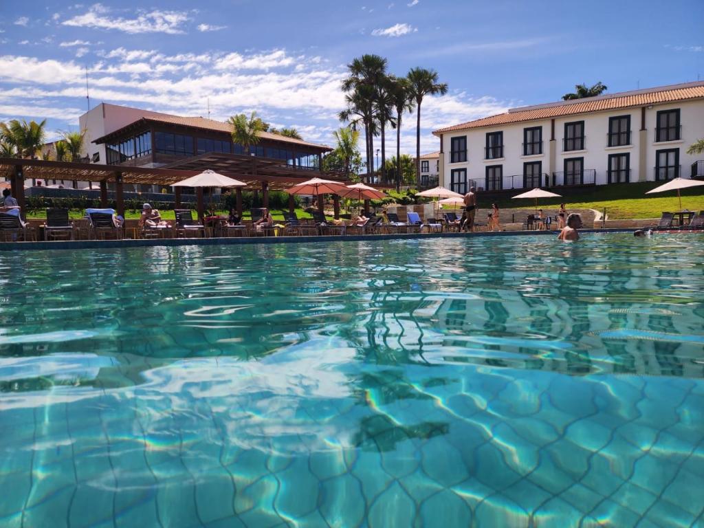 a large pool of water in front of a hotel at Resort Quinta Santa Barbara in Pirenópolis