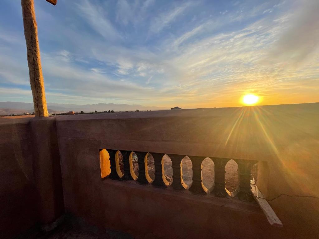 a sunset over a beach with the sun in the sky at AISHAMA Healing House in Aït Ourir