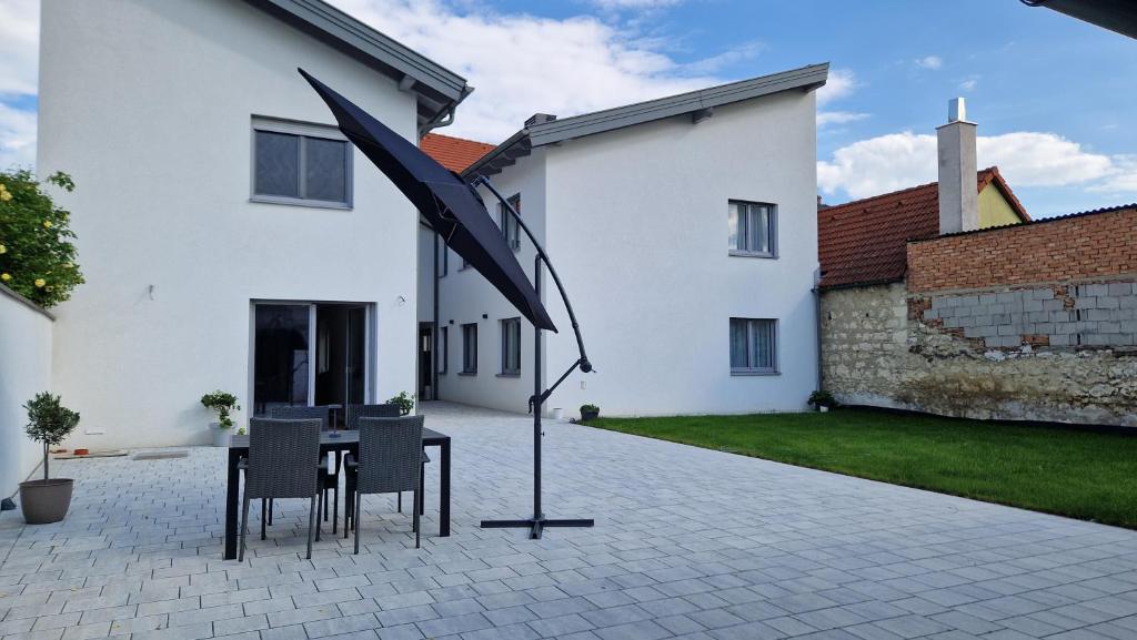 ブライテンブルンにあるAppartements Stadlerのパティオ(テーブル、椅子、パラソル付)