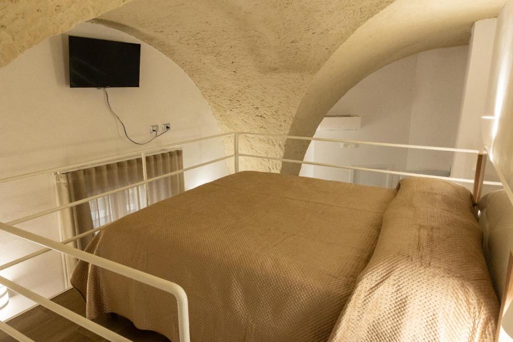 een slaapkamer met een bed en een tv aan de muur bij Le Casarelle in Gaeta