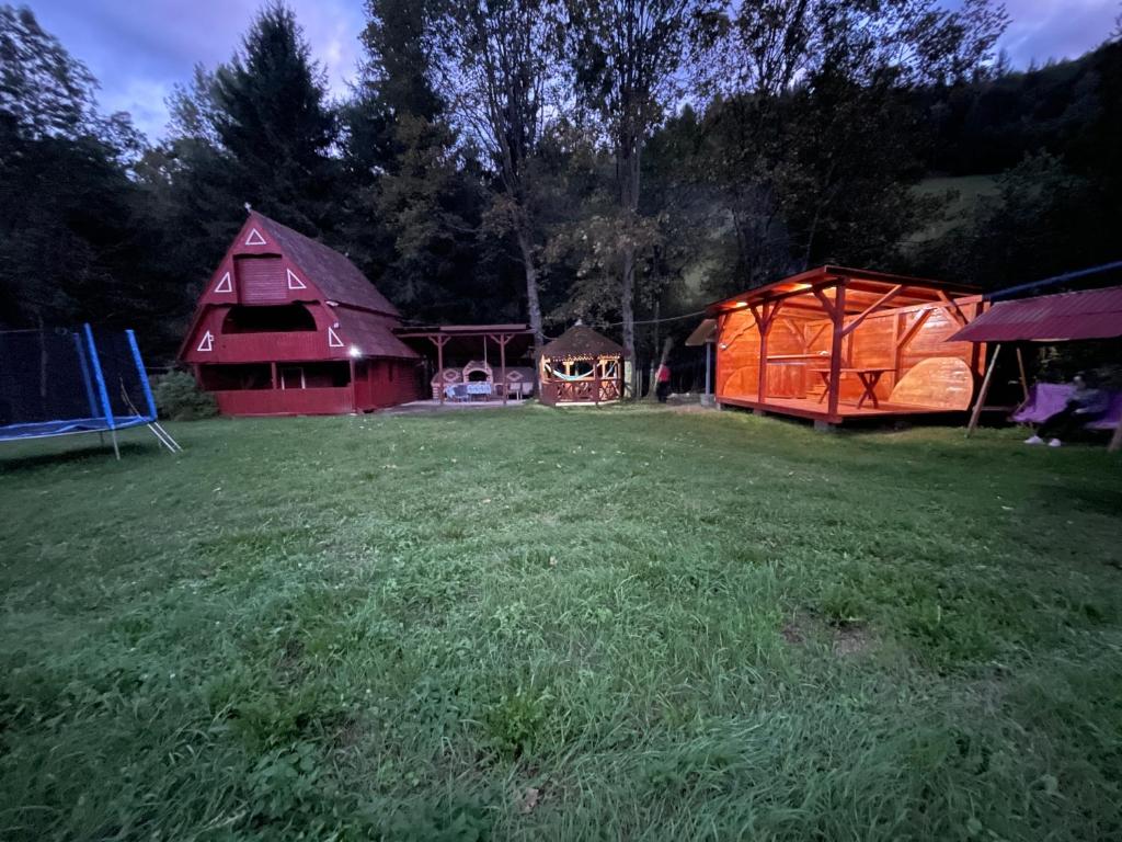 a field with two barns and a tent at Cabana Paltini 