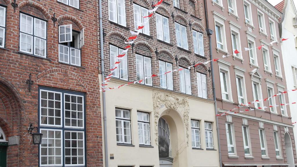 ein Backsteingebäude mit roten und weißen Flaggen darauf in der Unterkunft Apartments im Einhornhaus in Lübeck