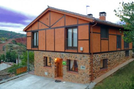 a large brick house with a large window at La Libélula de Valles in Puebla de Vallés