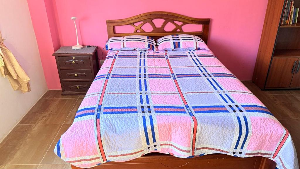 a bedroom with a bed with a colorful bedspread at Habitación 2 en Villa Mariaclaudia in Macas