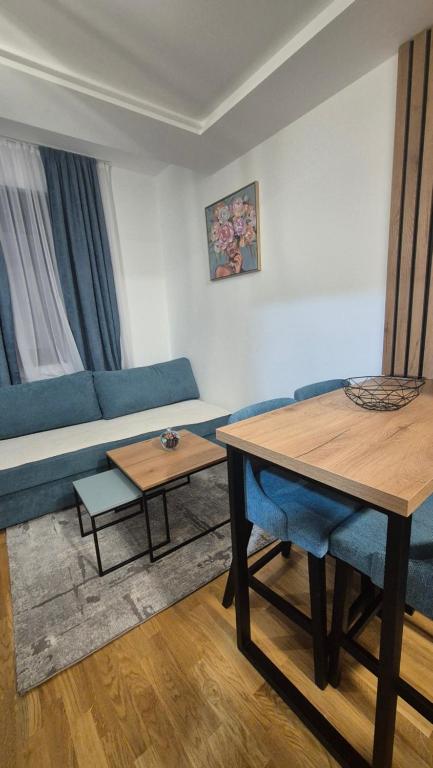 een woonkamer met een blauwe bank en tafels bij Srebrna pahulja in Zlatibor