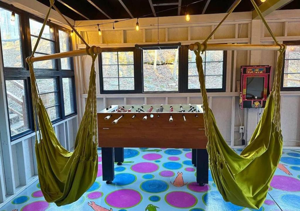 une pièce avec deux hamacs dans une salle de jeux dans l'établissement Waterfall Cottage, Hot Tub, Game Room, Fire Pit, à Mentone