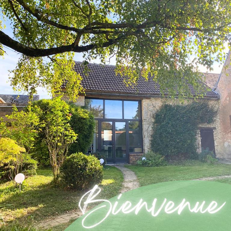 a house with a green yard with the word beware at Les maisons des Frangines in Oinville-Saint-Liphard