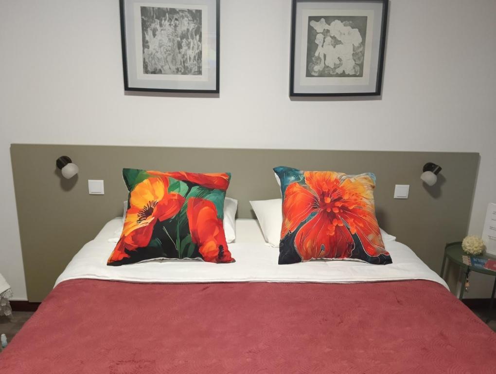 1 cama con 2 almohadas y manta roja en Aveiro Ria View, en Aveiro