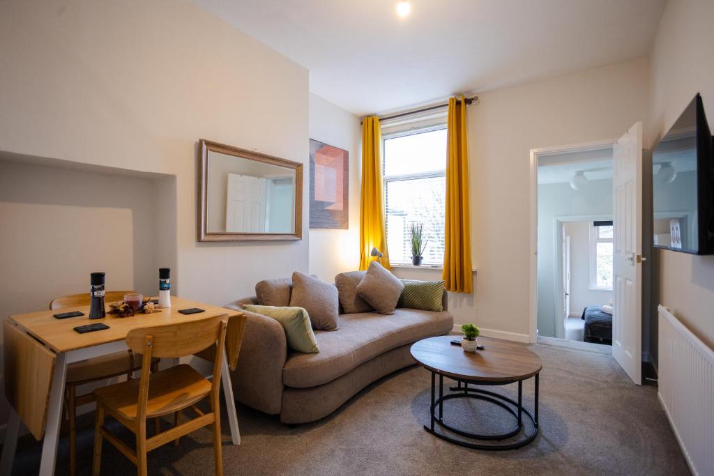 ein Wohnzimmer mit Sofa und Tisch in der Unterkunft Modern 2 BR Apt with Free parking in Cardiff Pontcanna in Cardiff