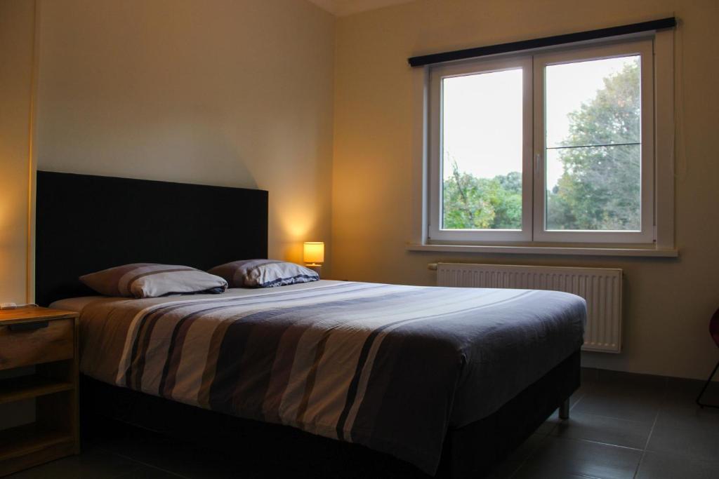 a bedroom with a large bed with a window at Aurelia in Zemst